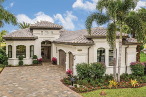 Florida home with beautiful brick driveway and lush garden